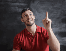 a man in a red shirt points his finger up