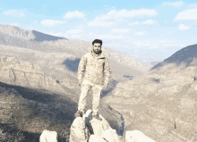 a man standing on top of a rocky hillside