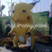 a child stands in front of a giant pikachu statue that says " preji krasny patek " on it