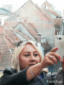 a woman taking a picture with a phone that says face app