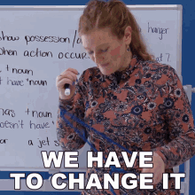 a woman stands in front of a white board with the words we have to change it written on it