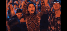 a group of people are dancing at a party with the line tv logo in the background