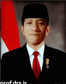 a man wearing a black hat and a red tie stands in front of an indonesian flag