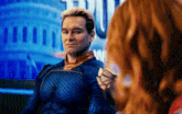 a man in a blue suit is sitting next to a woman with red hair ..