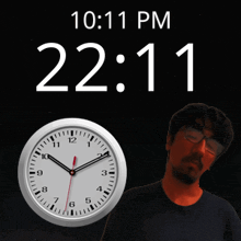 a man stands in front of a wall clock that says 10:11 pm