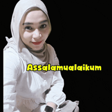 a woman wearing a hijab and a white shirt with the words assalamualaikum on the bottom