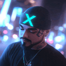 a man with a beard wears a beanie with a neon x on it