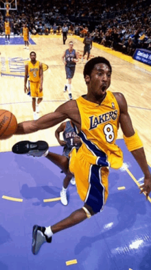 a basketball player for the lakers is jumping in the air with the ball