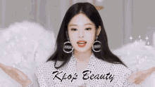 a woman wearing chanel earrings stands in front of a banner for kpop beauty