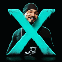 a man wearing a black beanie and a black shirt with a skull on it stands in front of a blue x