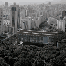 a black and white photo of a city with a large building in the foreground that says ' allianz ' on the side