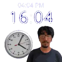 a man with glasses stands next to a clock that says 16:04