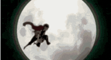 a silhouette of a person flying in the air in front of a full moon .