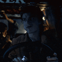 a man is driving a car with a sign that says ner on it