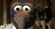 a close up of a stuffed animal with big eyes and a long beak