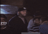 a man wearing a ny hat is standing next to a woman and two boys