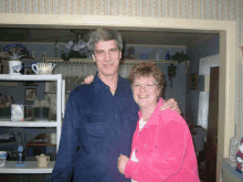 a man and woman are posing for a photo in a kitchen