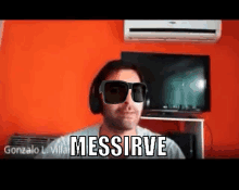 a man wearing sunglasses and headphones says messirve in front of a television