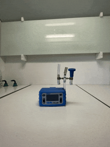 a blue device that says glair plus sits on a table