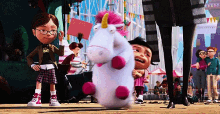 a stuffed unicorn with a pink horn is being held by a girl in glasses .