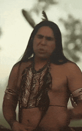 a man with long hair and feathers in his hair