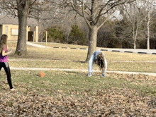 two girls are playing in a park with one wearing a shirt that says pink