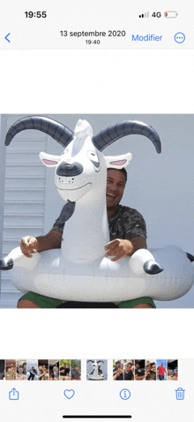 a man is sitting on an inflatable goat with horns