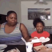 a woman and a little girl are sitting at a table with plates of food and a mcdonald 's cup .