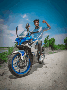 a young man is sitting on a blue and white motorcycle with a license plate that says rs200