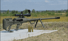 a sniper rifle with a scope and a few bullets on the ground