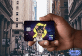 a person is holding a credit card with a cat on it and the letter s on it