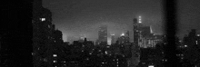 a black and white photo of the city skyline at night