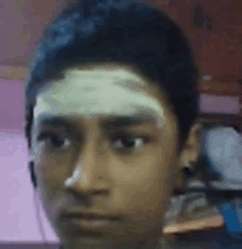 a man with a bandage on his forehead looks at the camera .