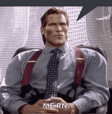 a man in a suit and tie is sitting in a chair and saying me rn