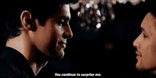 two men are looking at each other in a dark room and one of them is saying `` you continue to surprise me '' .