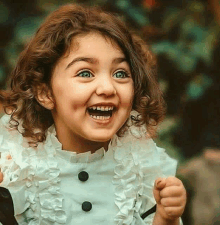 a little girl with curly hair is making a funny face .