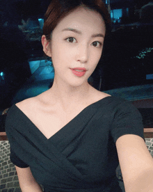 a woman in a black dress takes a selfie with her phone