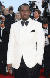 a man in a white suit and black bow tie