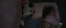 a girl is sleeping in a crib with stuffed animals and the words project exit on the bottom right