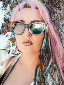 a woman with pink hair wearing sunglasses and a leather jacket