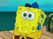 spongebob squarepants is wearing a blue hat and scarf while sitting on a dock .