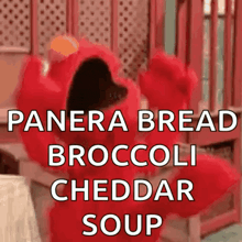 elmo from sesame street is wearing a panera bread broccoli cheddar soup outfit .