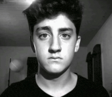 a black and white photo of a young boy with a serious look on his face