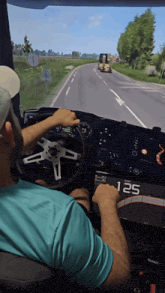 a man in a blue shirt is driving a truck with the number 125 displayed on the dashboard