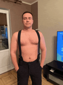 a shirtless man with suspenders stands in front of a tv screen that says " игры " on it