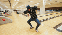 a man is dancing in a bowling alley with a sign on the wall that says ' a ' on it