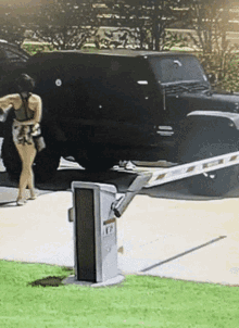 a woman walking in front of a black suv with a sticker on the back that says ' jeep '