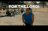 a man in a blue shirt stands in front of a group of people with the words for the lord above him