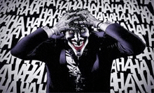 the joker is laughing with his hands on his head in front of a wall of laughing words .