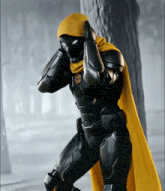 a black superhero with a yellow cape covering his face
